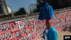 Une femme passe devant un mur couvert d'affiches &eacute;lectorales du Front de lib&eacute;ration du Mozambique (Frelimo) lors du premier jour de la campagne avant les &eacute;lections g&eacute;n&eacute;rales du 9 octobre, Maputo, le 24 ao&ucirc;t 2024.
