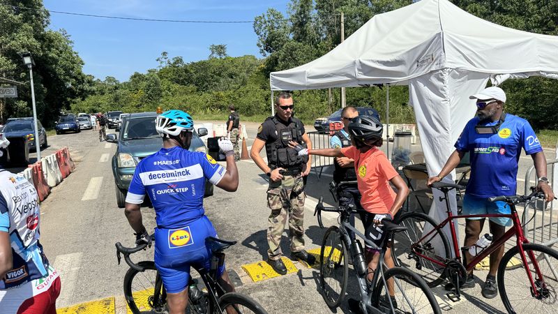 Les cyclistes de la Team 973 discutent vivement avec les gendarmes, cherchant &agrave; clarifier les circonstances de l'incident qui a marqu&eacute; le contr&ocirc;le routier de la veille.