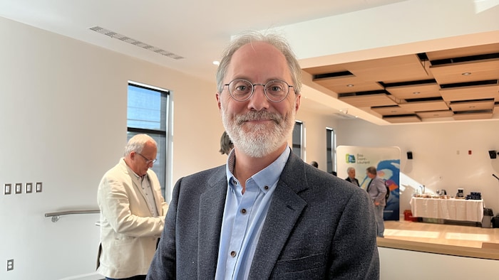 Patrick Morin dans une salle remplie d'&eacute;lus qui discutent en petits groupes. 